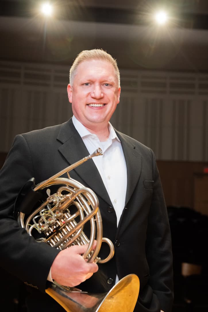 Jason M. Johnston holding a French horn